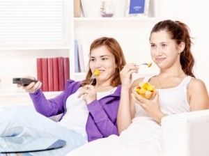 Girls eating and watching TV/freedigitalphotos