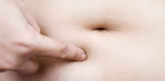 A lady pinching her bloaded belly/freedigitalphotos